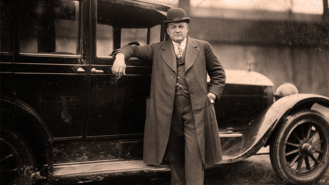A 1920s bootlegger in front of a car.
